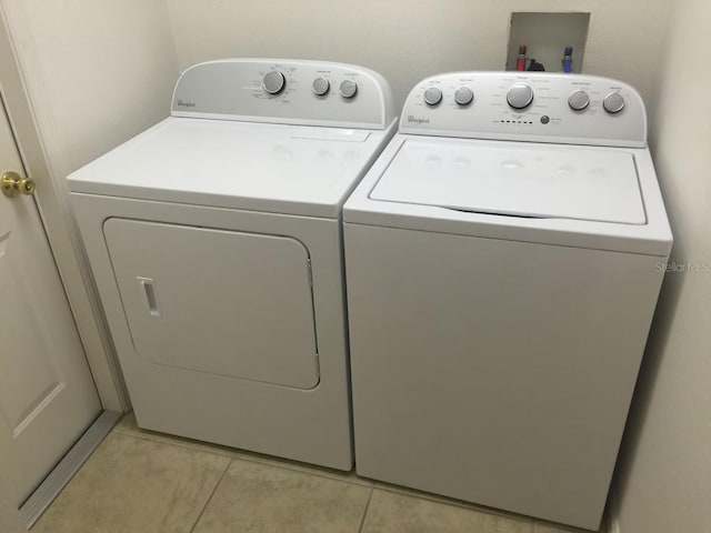 laundry area featuring light tile patterned floors and independent washer and dryer