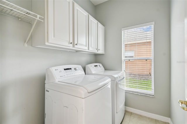 540 Genoa Dr, Poinciana, FL 34759 - laundry room featuring washer and clothes dryer, cabinet space, baseboards, and light tile patterned floors