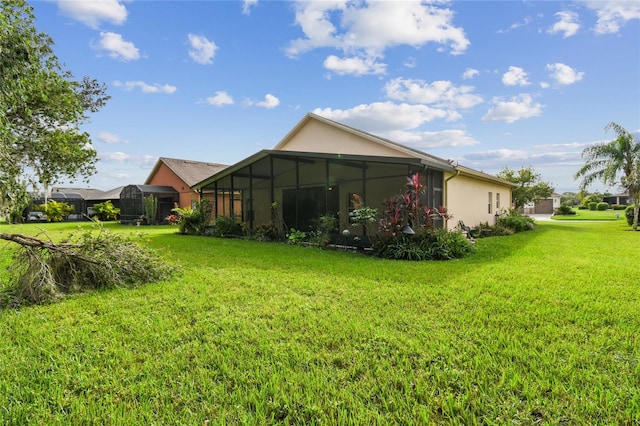 rear view of house with a lanai and a lawn