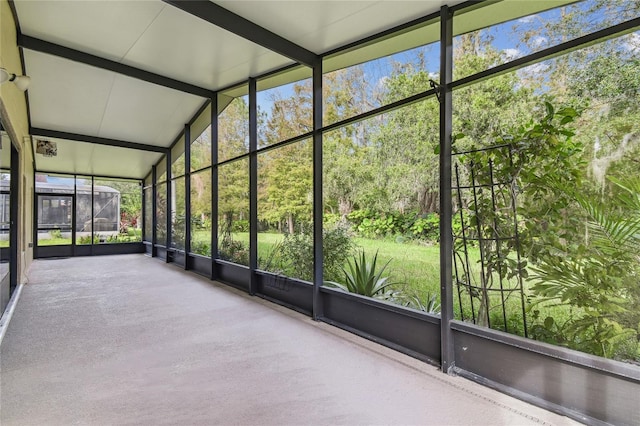 unfurnished sunroom featuring lofted ceiling with beams