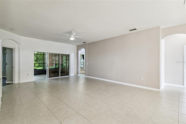 540 Genoa Dr, Poinciana, FL 34759 - empty room featuring arched walkways, ceiling fan, light tile patterned floors, a textured ceiling, and baseboards