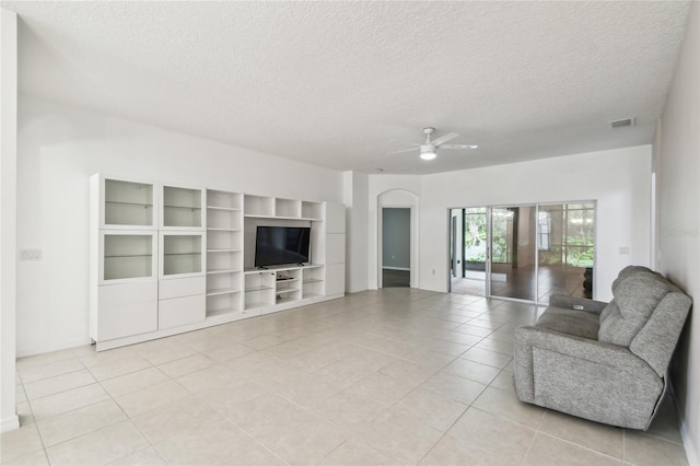 unfurnished living room featuring a textured ceiling, ceiling fan, and light tile patterned floors