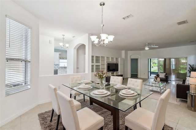 tiled dining space with ceiling fan with notable chandelier and sink