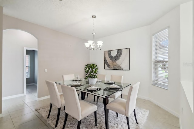 tiled dining space featuring an inviting chandelier