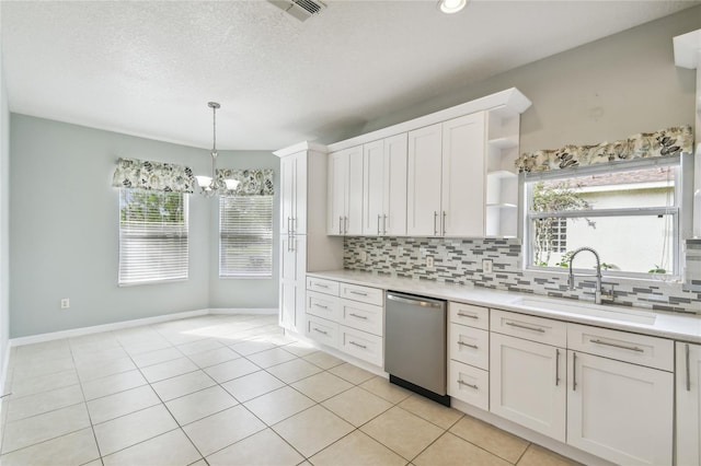 kitchen featuring stainless steel dishwasher, white cabinets, sink, and a notable chandelier