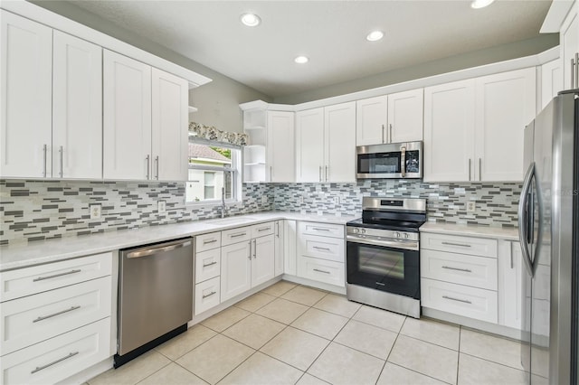 540 Genoa Dr, Poinciana, FL 34759 - kitchen with stainless steel appliances, a sink, open shelves, white cabinets, and light tile patterned flooring