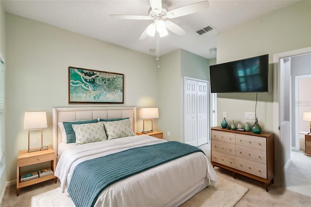 bedroom featuring ceiling fan, light carpet, and a closet