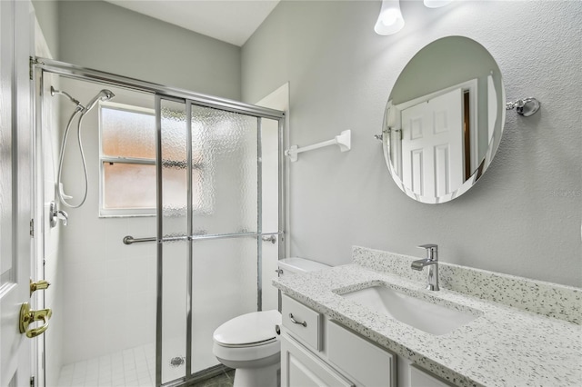 bathroom featuring an enclosed shower, vanity, and toilet