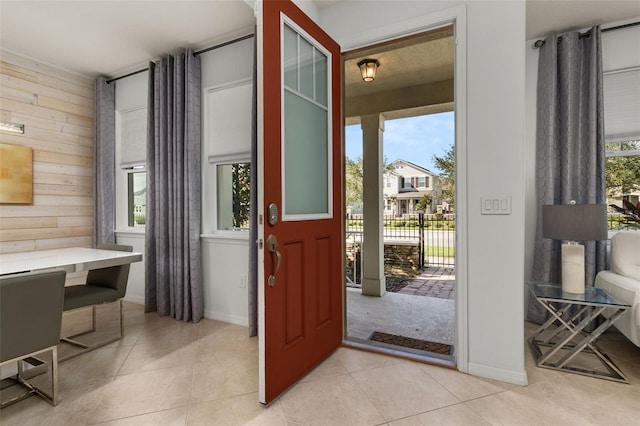 entryway featuring wood walls and light tile patterned floors