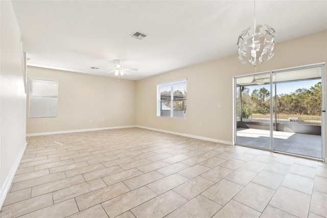 empty room featuring ceiling fan with notable chandelier