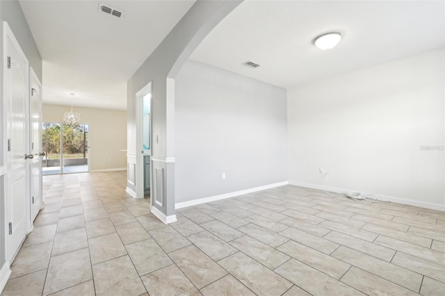 unfurnished room with a chandelier