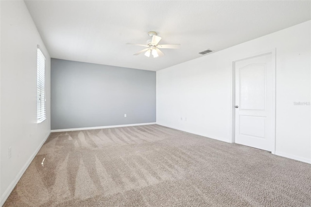 carpeted spare room featuring ceiling fan