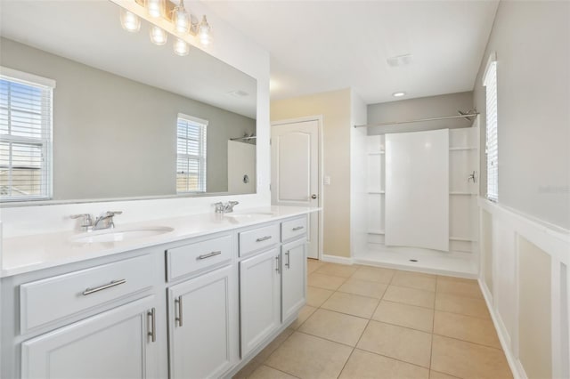 bathroom with tile patterned floors, walk in shower, and vanity