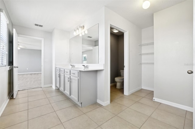 bathroom with ceiling fan, vanity, tile patterned floors, and toilet