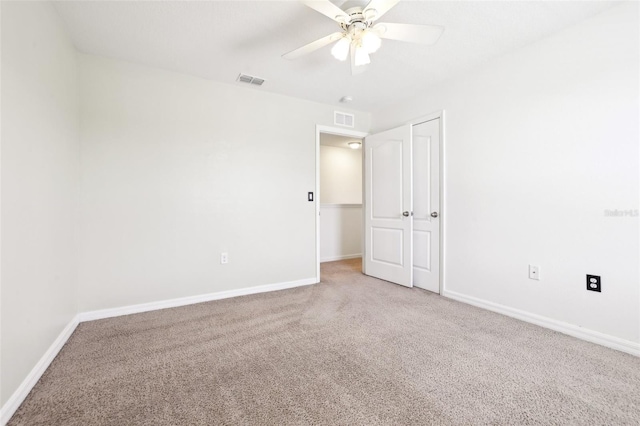 carpeted spare room with ceiling fan