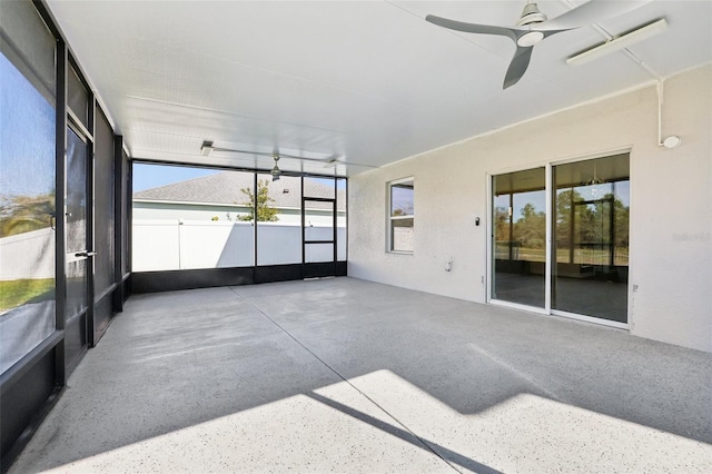 unfurnished sunroom with ceiling fan and plenty of natural light