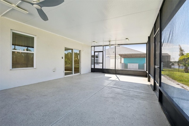 unfurnished sunroom with ceiling fan