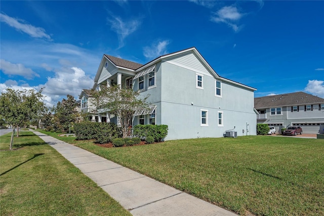 view of side of home with a garage, a lawn, and cooling unit