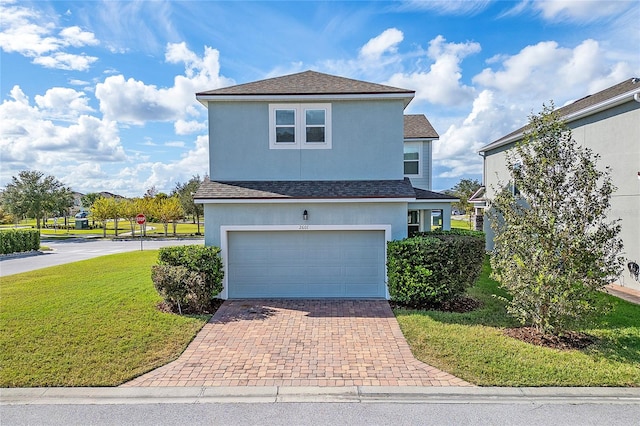 view of property featuring a garage and a front lawn