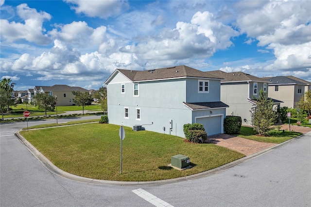 view of side of home with a garage, cooling unit, and a lawn