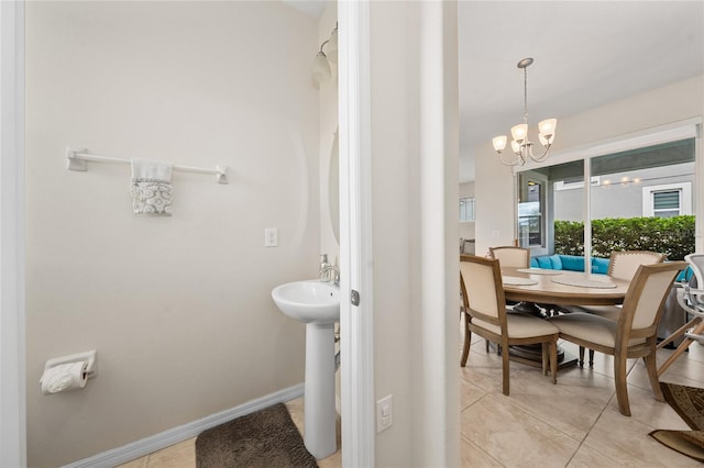 bathroom with tile patterned flooring, a notable chandelier, and sink