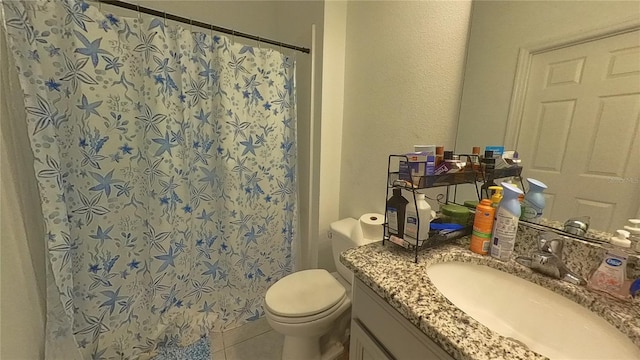 bathroom featuring toilet, vanity, a shower with shower curtain, and tile patterned floors