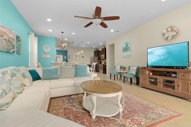 tiled living room with ceiling fan with notable chandelier