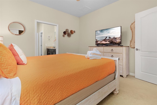 bedroom with light carpet and ensuite bath