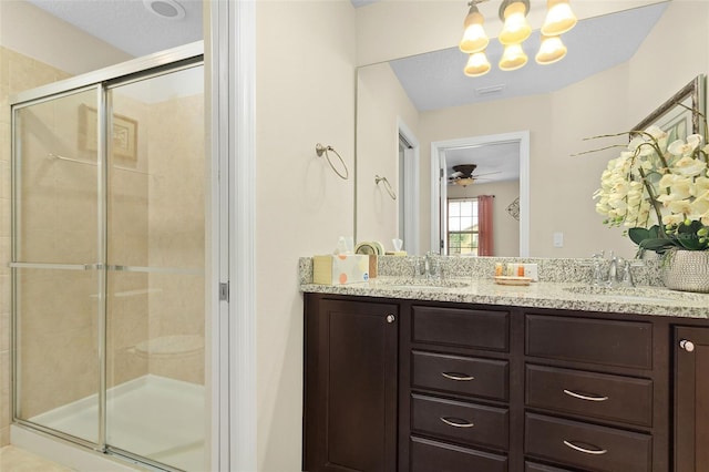 bathroom with vanity, a shower with door, and ceiling fan