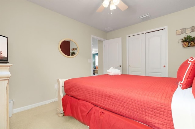 bedroom featuring a closet, light colored carpet, and ceiling fan