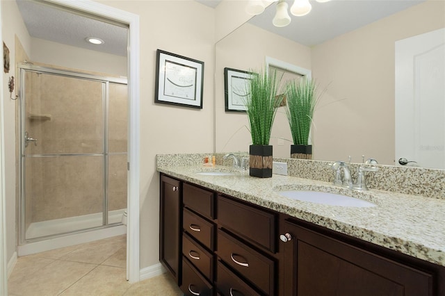 bathroom with toilet, tile patterned flooring, a textured ceiling, vanity, and walk in shower