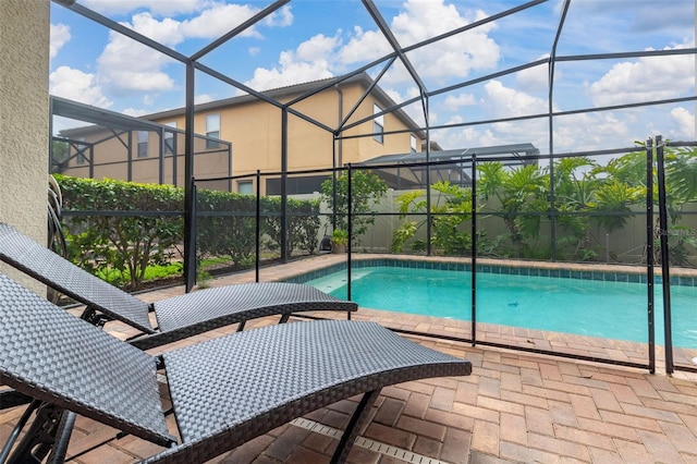 view of pool featuring glass enclosure and a patio