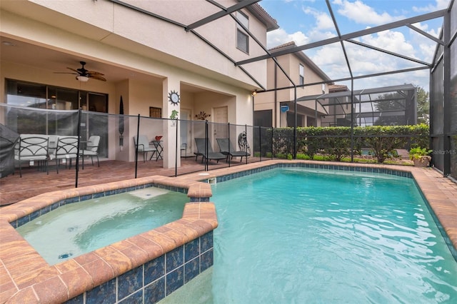 view of pool with glass enclosure, a patio area, ceiling fan, and an in ground hot tub