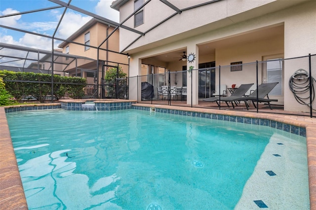 view of swimming pool with ceiling fan, a lanai, and a patio area