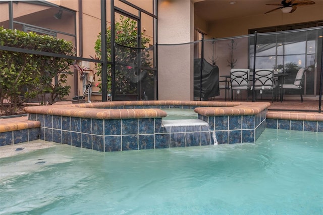 view of swimming pool with a jacuzzi, a grill, glass enclosure, and pool water feature