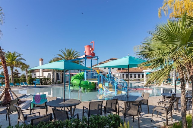 view of jungle gym featuring a community pool and a patio area