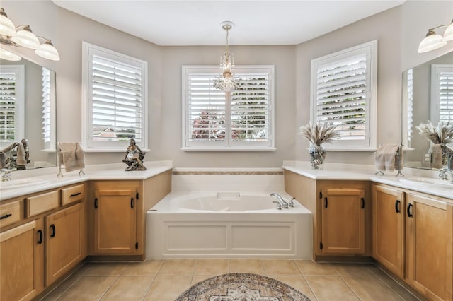 bathroom with a bath, a chandelier, tile patterned floors, and vanity