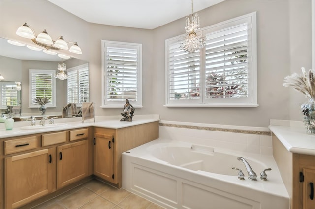 bathroom with a bathtub, vanity, a wealth of natural light, and tile patterned flooring