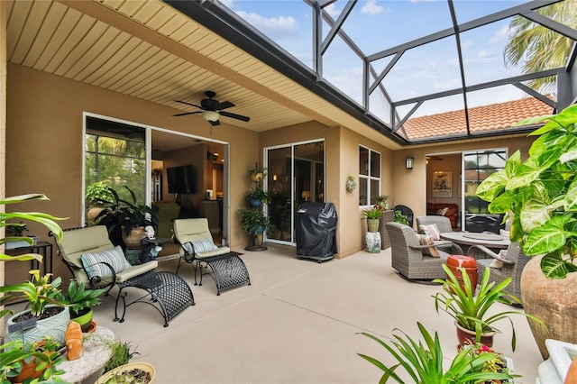 view of patio / terrace featuring glass enclosure, a grill, outdoor lounge area, and ceiling fan