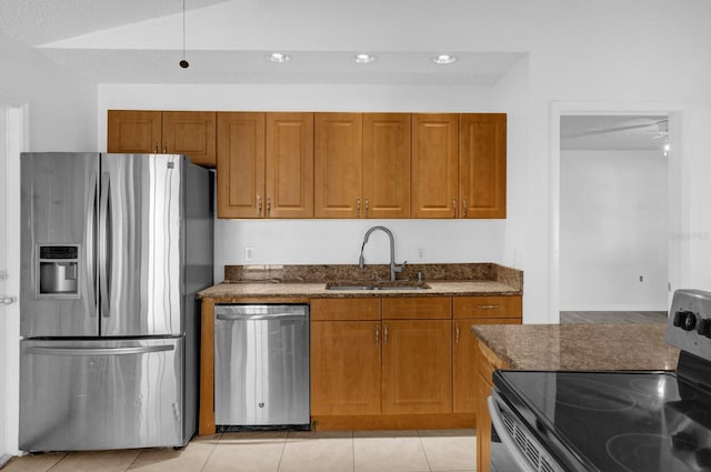 kitchen with appliances with stainless steel finishes, a textured ceiling, light tile patterned floors, and sink