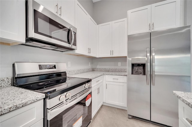 kitchen with white cabinetry, light stone countertops, and appliances with stainless steel finishes