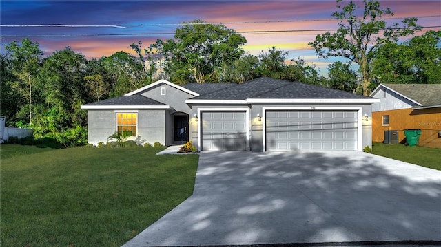 single story home featuring a lawn, cooling unit, and a garage