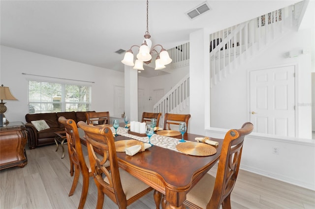 dining area featuring light hardwood / wood-style flooring and a notable chandelier