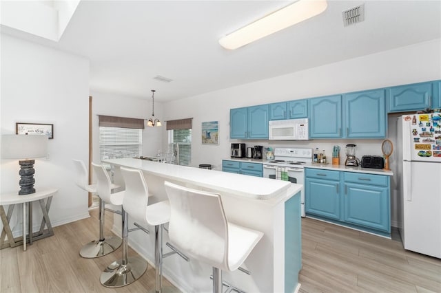 kitchen featuring light hardwood / wood-style flooring, blue cabinetry, white appliances, and hanging light fixtures