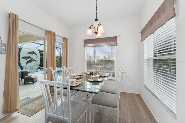 dining space featuring an inviting chandelier, a healthy amount of sunlight, and light hardwood / wood-style flooring