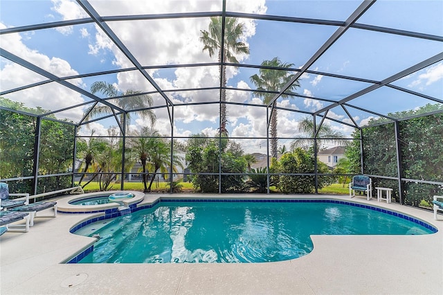 view of pool with a patio, glass enclosure, and an in ground hot tub