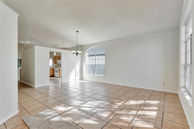 interior space with a notable chandelier, light tile patterned floors, and a textured ceiling