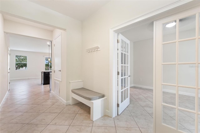 corridor with french doors and light tile patterned floors