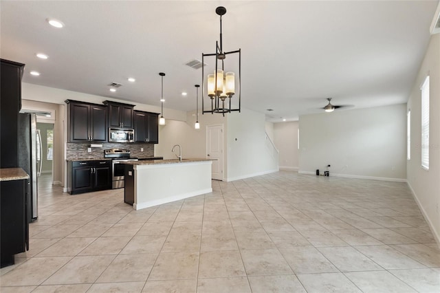 kitchen with a wealth of natural light, ceiling fan with notable chandelier, pendant lighting, and appliances with stainless steel finishes