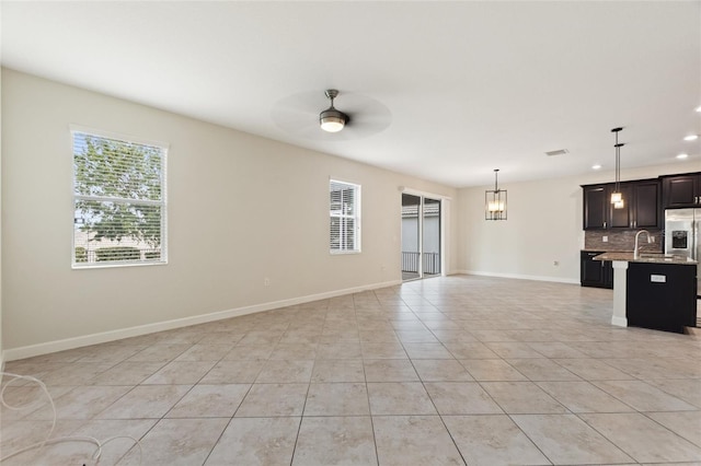 unfurnished living room with ceiling fan and light tile patterned floors